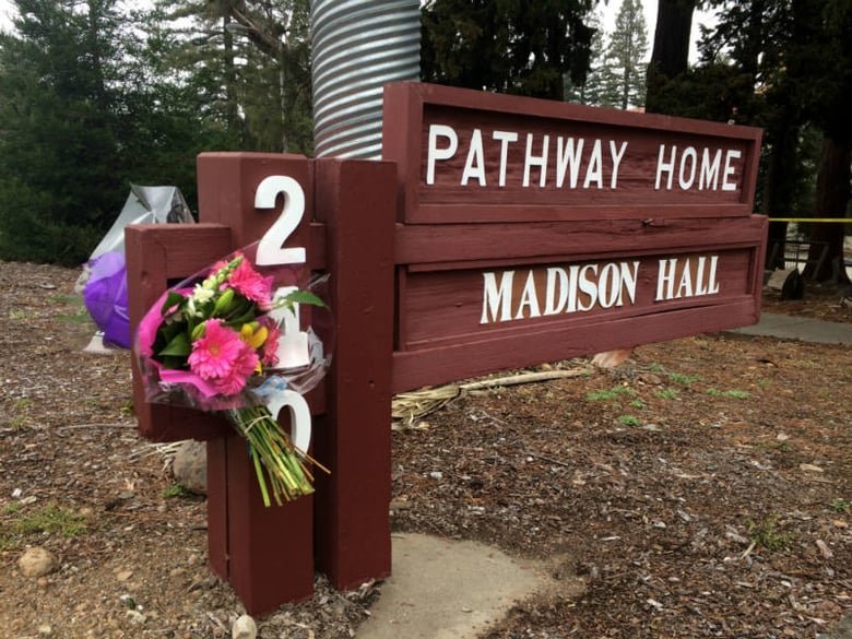 In this March 10, 2018, file photo, flowers adorn the sign in front of Pathway Home, the building that houses a veterans program in Northern California a day after a deadly shooting in Younteville, Calif.